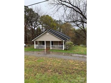 Charming single-story home featuring a welcoming porch, neutral siding, and a contrasting black roof at 1336 Mt Sinai Church Rd, Shelby, NC 28152