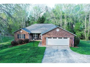 Charming brick home features a two-car garage, manicured lawn, and mature trees at 1353 33Rd Avenue Ne Dr, Hickory, NC 28601