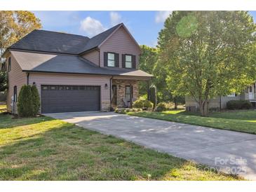 Two-story home with a gray garage door, covered front porch, stone accents and a long concrete driveway at 1650 Berkshire Dr, Hickory, NC 28602