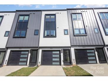 Contemporary townhome showcasing a sleek design with mixed materials and black garage doors at 3526 Saker Ln, Charlotte, NC 28211