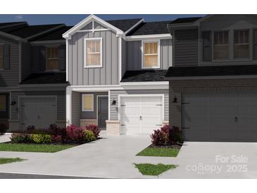 Charming two-story townhome featuring a modern design, white garage door, and low maintenance landscaping at 4325 Summit Woods Dr, Charlotte, NC 28216