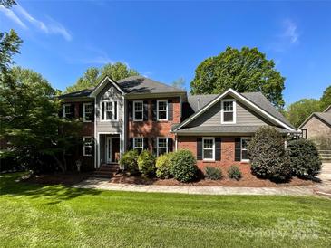 Stately two-story brick home with lush landscaping, mature trees, and a well-manicured lawn at 4823 Antioch Church Rd, Weddington, NC 28104