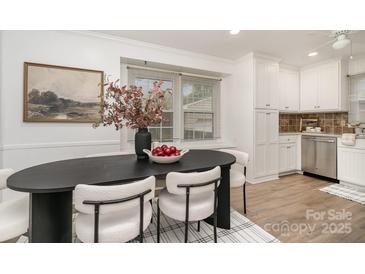 Bright dining room with modern oval table, decor, and stylish chairs next to a window at 5329 Glenbrier Dr, Charlotte, NC 28212