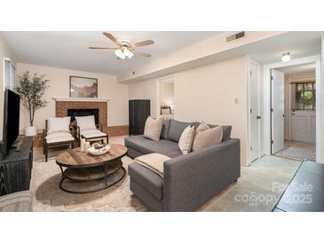 Cozy living room with a brick fireplace, comfortable seating, and neutral tones create an inviting atmosphere at 5329 Glenbrier Dr, Charlotte, NC 28212