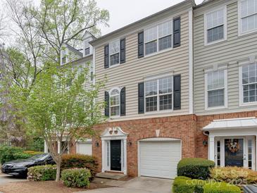 Beautiful townhome with brick accents, a manicured lawn, and a one car garage at 5430 Dockery Dr, Charlotte, NC 28209