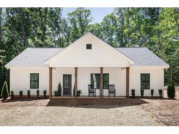 Charming home features a welcoming front porch with rocking chairs and a well-maintained yard at 676 Chapel Hill Dr, Troy, NC 27371