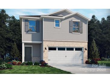 Charming two-story home featuring gray siding, brick accents, and an attached two-car garage at 811 Blue Canyon Dr, York, SC 29745