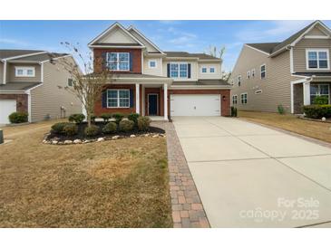 Charming two-story home featuring a brick facade, blue shutters, landscaped yard and a two car garage at 1082 Wallace Lake Rd, Fort Mill, SC 29707