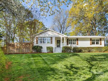 Charming painted brick home featuring a well-manicured lawn, inviting curb appeal, and a spacious front yard at 1210 Sewickley Dr, Charlotte, NC 28209