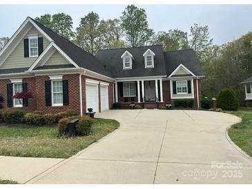 Inviting front exterior featuring a brick facade, well-manicured lawn, and a spacious driveway leading to an attached garage at 127 Victoria Park Dr, Shelby, NC 28150