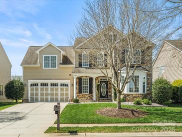 Charming two-story home with a manicured lawn, two-car garage, and stone accents on the facade at 1528 Ridge Haven Rd, Waxhaw, NC 28173