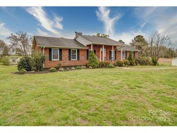 Charming single-story brick home featuring a well-kept lawn and beautiful landscaping at 24436 Nc 24/27 Hwy, Albemarle, NC 28001