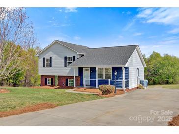 Charming two-story home featuring gray and blue siding, black shutters, and a well-maintained front yard with mature trees at 2948 Christy Leigh Dr, Newton, NC 28658
