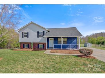 Charming home with light gray and blue siding, black shutters, and a green lawn with mature trees under a blue sky at 2948 Christy Leigh Dr, Newton, NC 28658