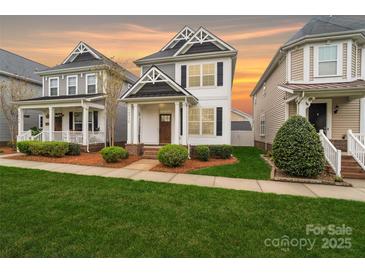 Charming two-story home featuring a manicured lawn and beautifully landscaped front yard with craftsman details at 13712 Bonnerby Ct, Huntersville, NC 28078