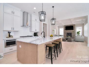 Bright, open kitchen boasts marble countertops, stainless steel appliances, and a view into the cozy living room at 1378 Cedardale Ln, Denver, NC 28037