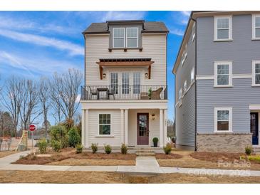 Charming two-story home featuring a cozy balcony, well-manicured landscaping, and inviting curb appeal at 221 Davidson Gateway Dr, Davidson, NC 28036