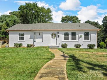 Charming single-story home featuring a well-manicured lawn and a welcoming walkway to the front door at 2633 N Sharon Amity Rd, Charlotte, NC 28205