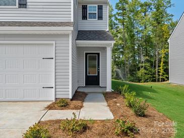 Close-up of the front entrance featuring a black door, manicured landscaping, and a welcoming porch at 3034 Trailblazer St, Charlotte, NC 28215