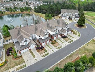 Beautiful aerial view of townhomes, landscaped grounds, and a serene pond with a fountain feature at 44455 Oriole Dr # 100, Indian Land, SC 29707