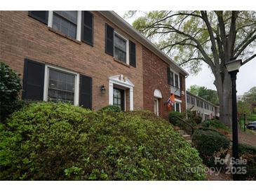Brick townhome featuring dark shutters, tasteful landscaping, and classic architectural elements, offering a blend of charm and curb appeal at 4609 Hedgemore Dr # I, Charlotte, NC 28209