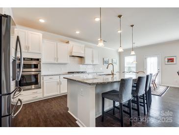Bright kitchen boasts white cabinets, granite counters, and stainless steel appliances at 2052 Donaldson St, Indian Land, SC 29707