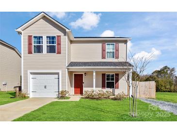 Charming two-story home with a well-maintained lawn, a garage, and a welcoming front porch with red door and shutters at 213 Morton St, Shelby, NC 28152