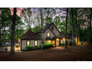 Stunning two-story home with a beautifully landscaped yard surrounded by mature trees and waterfront access at 252 Greyfriars Rd, Mooresville, NC 28117