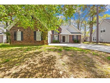 Charming brick home featuring a well-maintained lawn and a long driveway at 3002 Enderbury Dr, Indian Trail, NC 28079