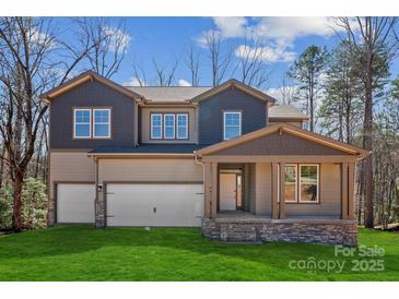 New construction home featuring a two-car garage, covered porch, and professionally landscaped lawn at 7117 Cobblefield Ln, Denver, NC 28037