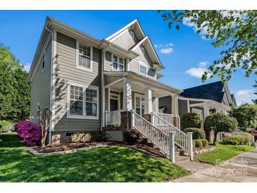 Charming home featuring a well-manicured lawn and welcoming front porch with stylish white railings at 8311 Camberly Rd, Huntersville, NC 28078