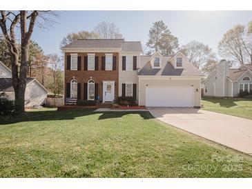 Charming two-story home with brick and siding, a two-car garage and a lush, green front yard at 8718 Canter Post Dr, Charlotte, NC 28216
