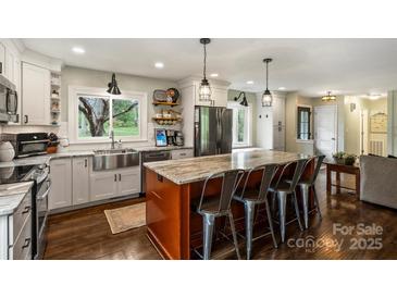 Beautiful kitchen with large island, stainless appliances, and farmhouse sink at 9025 Shields Dr, Huntersville, NC 28078