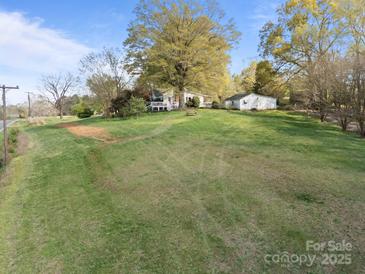 Expansive lawn and charming single-story house and garage, perfect for outdoor activities and serene country living at 11170 Nc Hwy 73 E Hwy, Mount Pleasant, NC 28124