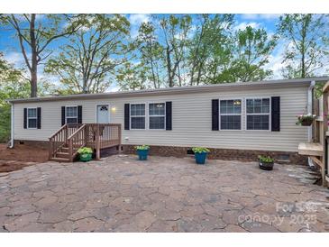 Inviting single-story home with a charming entrance, beautiful stone front patio, and manicured landscaping at 2749 Old Nation Rd, Fort Mill, SC 29715