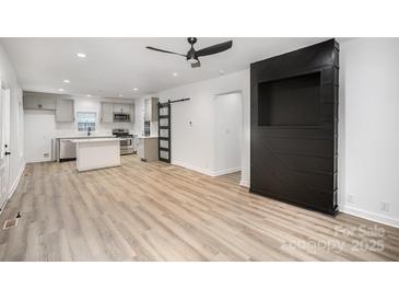 Open-concept living space featuring updated kitchen, modern flooring, and contemporary accents at 308 Birch St, Lowell, NC 28098