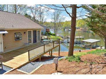 Stunning backyard with a wooden deck overlooking the serene lake and private dock at 458 Pinehaven Dr, Badin Lake, NC 28127