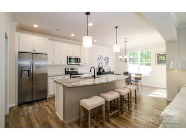 Modern kitchen with stainless steel appliances, granite countertops, and a breakfast bar at 7036 Heron Rookery Way, Charlotte, NC 28214
