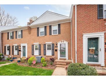 Charming brick townhome featuring black shutters, a landscaped yard, and a welcoming front entrance at 8308 Knights Bridge Rd, Charlotte, NC 28210
