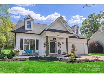 Charming home featuring dormer windows, a covered porch with seating, manicured lawn and a welcoming entryway at 835 Ryans Pl, Fort Mill, SC 29715