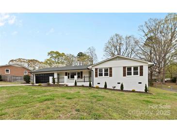 Charming brick home with fresh white paint, black trim, and well-manicured lawn at 121 Tanglewood Dr, Kannapolis, NC 28081
