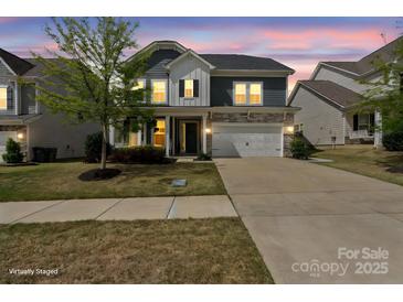 Charming two-story home featuring stone accents, a two-car garage, manicured lawn, and covered porch entry at 15126 Shallow Ridge Rd, Charlotte, NC 28278