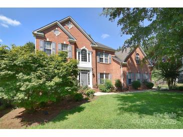 Charming two-story brick home with manicured lawn and mature landscaping at 15964 Cumnor Ln, Charlotte, NC 28277