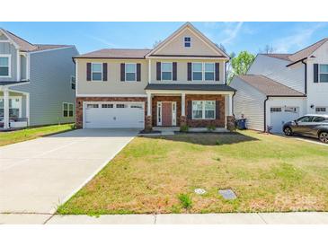 Charming two-story home with a two-car garage, manicured lawn, and covered front porch at 162 Aspire Cir, Wingate, NC 28174