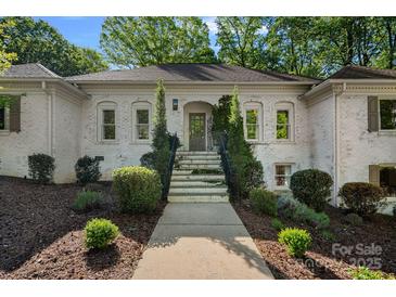 Traditional home with a painted brick exterior and professionally landscaped front yard and entry at 2915 Cross Country Rd, Charlotte, NC 28270