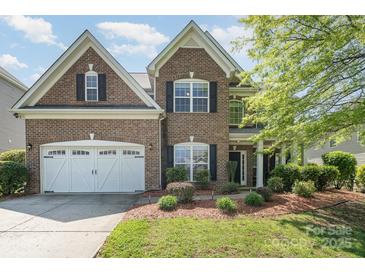 Charming two-story brick home with a well-manicured lawn and a two-car garage at 9013 Gailes Dr, Charlotte, NC 28278