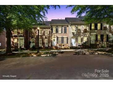 Charming brick townhomes featuring well-maintained landscaping and classic architectural details at twilight at 164 Singleton Rd, Mooresville, NC 28117