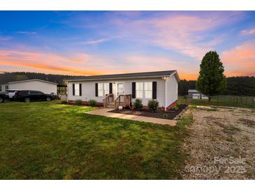 Charming single-story home with a metal roof, well-maintained lawn, and inviting front porch at 34958 Lowder Rd, New London, NC 28127