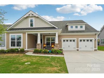 Charming home featuring a manicured lawn, inviting porch, and a convenient two-car garage enhancing curb appeal at 4004 Henshaw Rd # 448, Waxhaw, NC 28173
