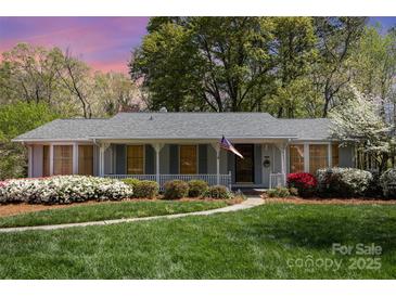 Charming single-story home with inviting front porch, manicured lawn, and lush, colorful landscaping at 726 Grandview Ne Dr, Concord, NC 28025